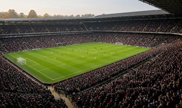 Fullsatt engelsk fotbollsarena sedd från övre läktaren under en Premier League-match en höstdag